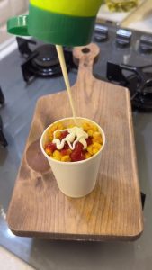 Final presentation of Turkish cup corn served with a drizzle of ketchup and mayonnaise.