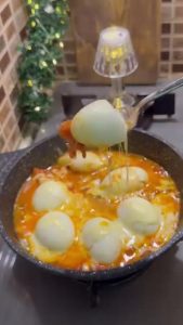 Serving the finished cheesy egg skillet with slices of fresh bread.