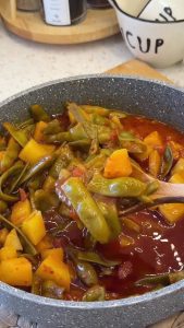Serving the glossy, olive-oil-rich green beans alongside a bowl of white rice.