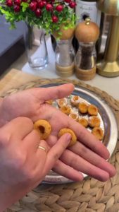 Rolling small hazelnut-sized pieces of dough into balls with dampened hands.