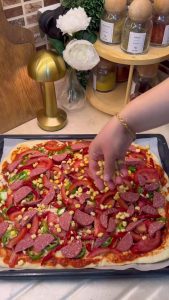 A large tray of pizza baking inside a preheated oven at 200 degrees Celsius