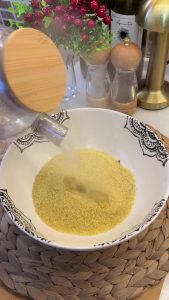 Soaking fine bulgur in a bowl with boiling water to let it bloom.