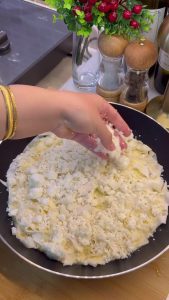 Pouring the egg and milk sauce over the first layer of yufka in the pan.