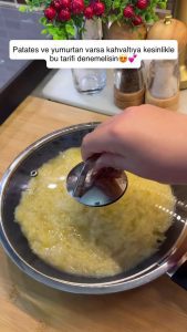 Pouring the potato-egg mixture into a greased pan and spreading it evenly.