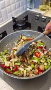 Stir-frying the vegetable and mushroom mixture in a skillet until soft and fragrant.