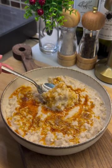 A plate of creamy Turkish Keşkek topped with sizzling red pepper butter.