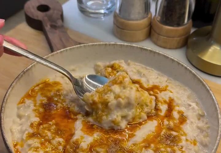 A plate of creamy Turkish Keşkek topped with sizzling red pepper butter.