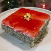 A slice of Turkish poppy seed revani cake with white cream and red forest fruit sauce layers.