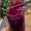 A glass jar filled with bright pink-purple pickled Turkish red cabbage.