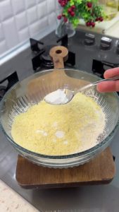 Whisking all-purpose flour, cornmeal, salt, and baking powder in a glass mixing bowl.