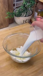 Whisking fresh milk and vegetable oil in a bowl for the börek glaze.