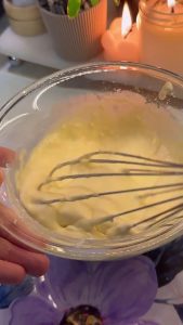 Whisking eggs, milk, and flour in a bowl to create a smooth frying batter.