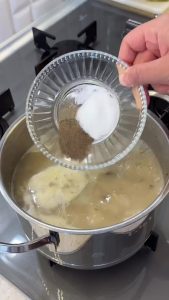 Gradually whisking room temperature water into the mushroom and flour mixture to avoid lumps.