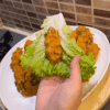 A beautiful arrangement of red lentil balls on a bed of lettuce with lemon wedges.