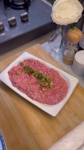 Adding walnuts and parsley to a pink beetroot dip.