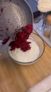 Stirring sautéed beets into white garlic yogurt.