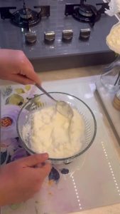 Mixing garlic, yogurt, and mayo in a white bowl.