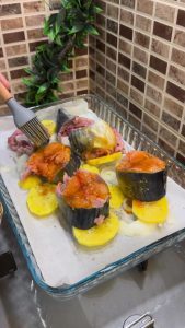 Brushing garlic and lemon sauce over bonito fish slices.