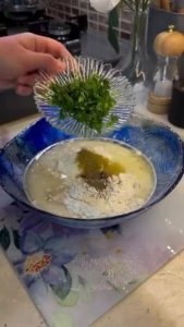 Adding cumin and fresh parsley to the yogurt custard.
