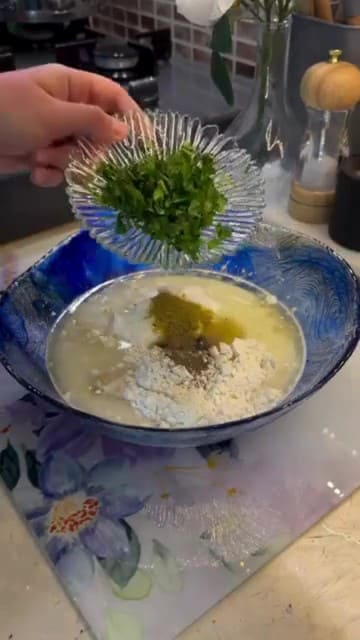 Adding cumin and fresh parsley to the yogurt custard.