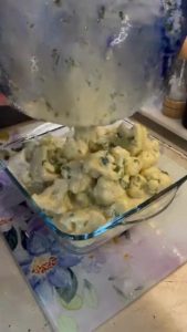 Mixing boiled cauliflower with a creamy yogurt and egg sauce.
