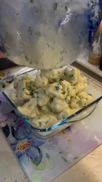 Mixing boiled cauliflower with a creamy yogurt and egg sauce.
