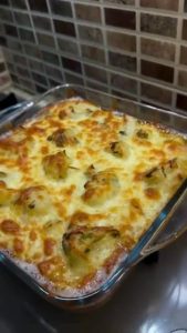 Adding grated kashar cheese on top of a cauliflower bake.