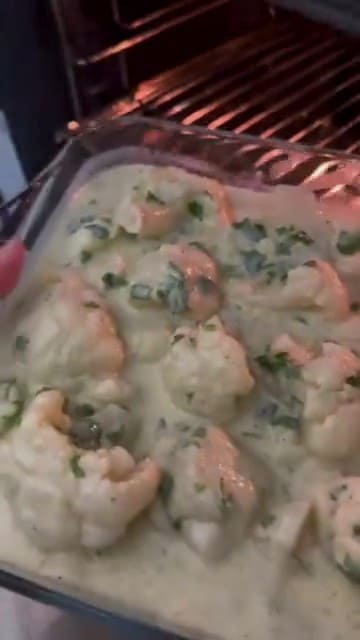 Pouring the cauliflower mixture into a greased Borcam.