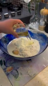 Whisking yogurt, eggs, and milk for a gratin sauce.