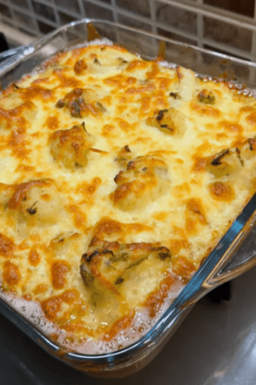 A golden-brown cheesy cauliflower gratin served in a glass baking dish.