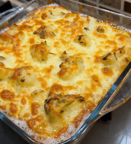 A golden-brown cheesy cauliflower gratin served in a glass baking dish.