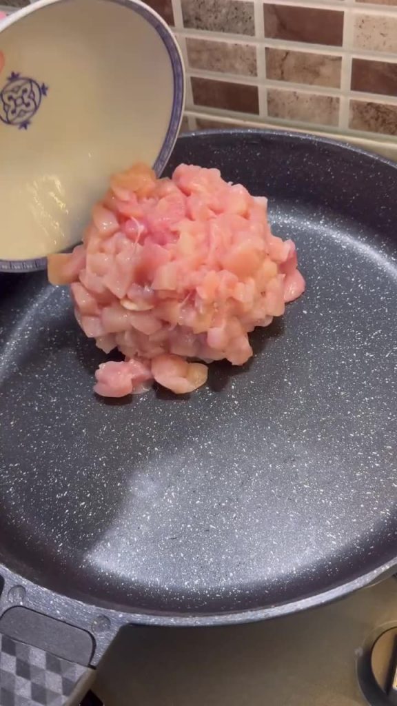 Finely dicing chicken breast into small cubes for Tantuni.