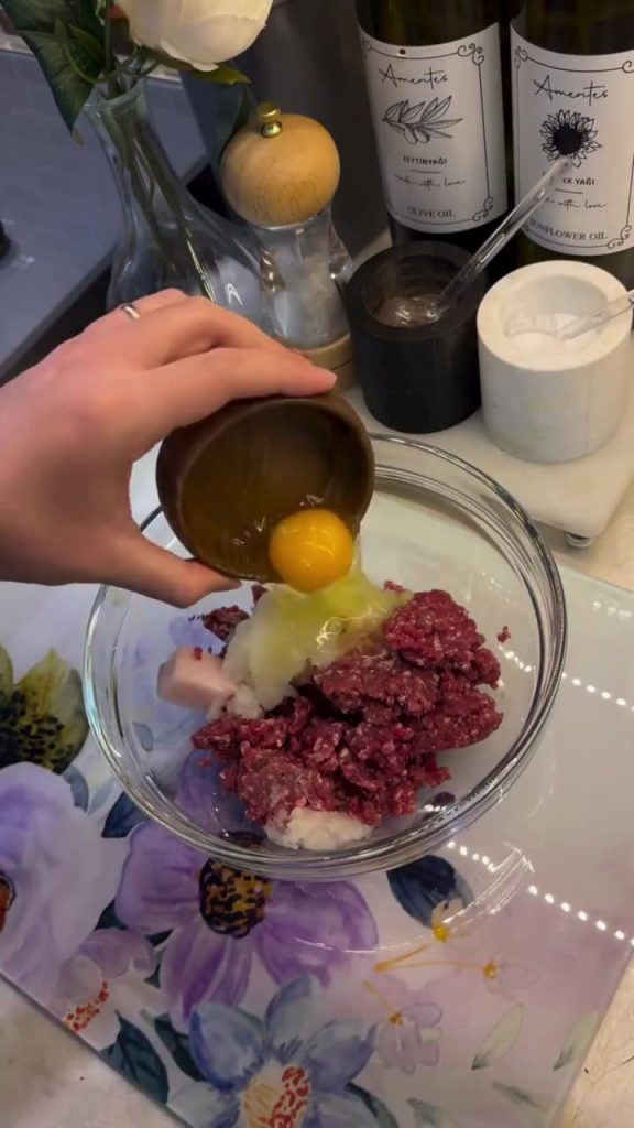 Kneading seasoned ground beef and breadcrumbs for Turkish meatballs.