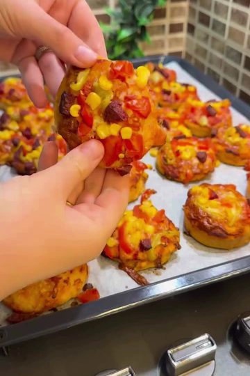 A platter of colorful mini pizzas with melted cheese and sucuk.