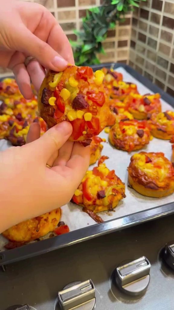 A platter of colorful mini pizzas with melted cheese and sucuk.