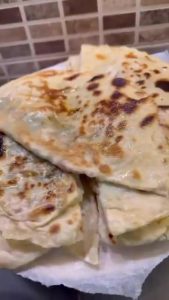 Brushing hot Turkish flatbread with melted butter.
