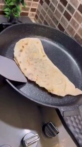 Frying gözleme on a non-stick pan until golden.