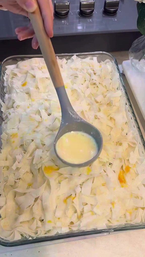 Pouring the remaining mineral water sauce over the top layer of borek.