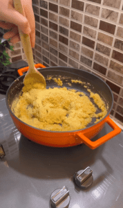 Mixing fine bulgur into cooked red lentils.