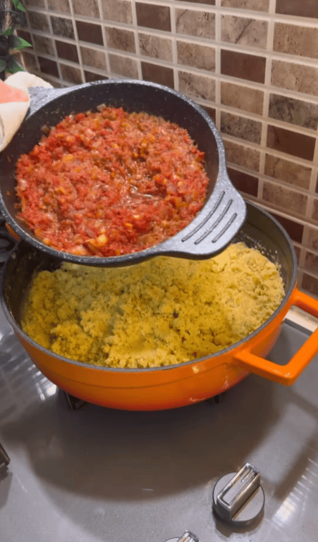 Pouring a savory red sauce over soaked lentils and bulgur.