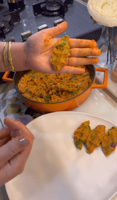 Hand-shaping Turkish red lentil balls into small logs.