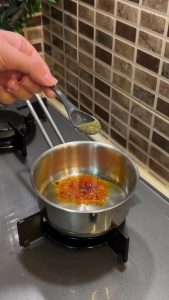 Whisking garlic and yogurt for a Turkish pasta topping.
