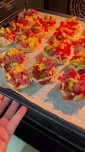 Baking mini pizzas in a 170 degree oven on a baking sheet.