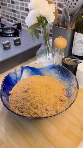 Crushing tea biscuits in a food processor for a cake base.