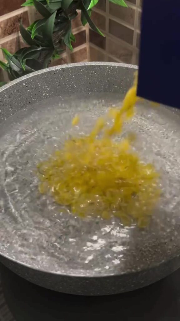 Boiling pasta in a pot for a Turkish yogurt salad.