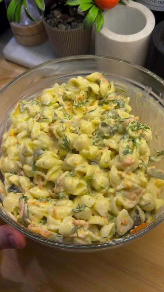 Mixing the Turkish pasta salad until creamy and even.