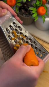 Sautéing grated carrots in a skillet for pasta salad.