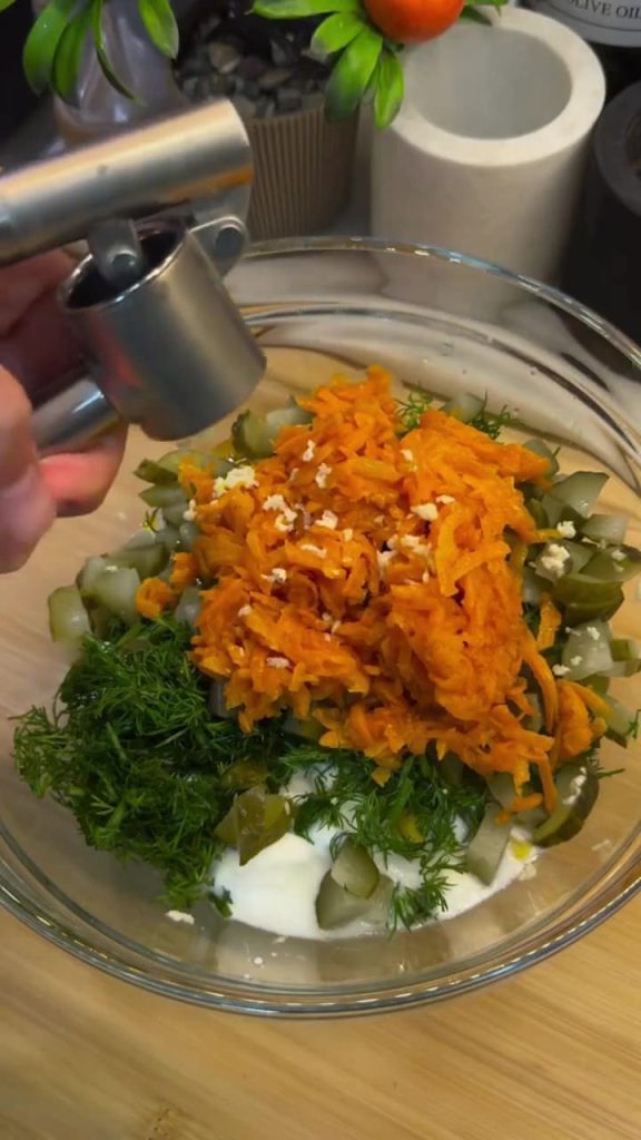 Whisking yogurt, mayo, and garlic together for the dressing.