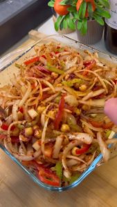 Mixing chickpeas and vegetables with spices and oil.