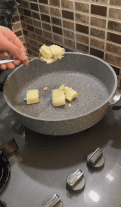 Roasting semolina with butter in a stovetop pot.